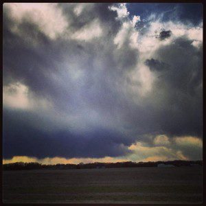 Dark storm clouds over an open field.