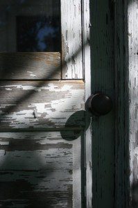 Weathered wooden door with shadowed knob.