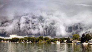 Dramatic storm clouds over lakeside houses.