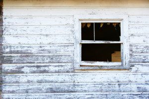 Old weathered wall with broken window.